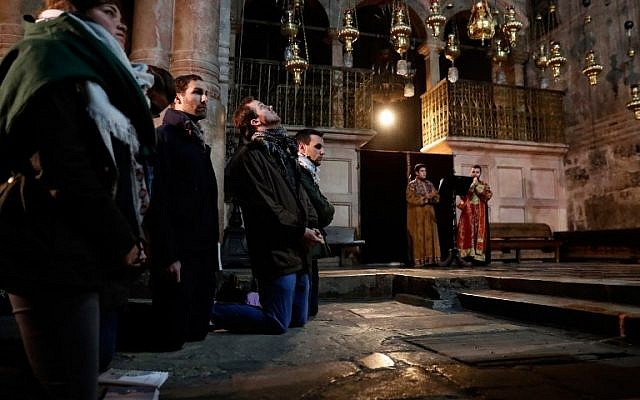 Christian worshippers pray inside the Church of the Holy Sepulchre in Jerusalem after it reopened on February 28, 2018, following a three-day closure to protest against Israeli tax measures and a proposed law. (AFP / THOMAS COEX)