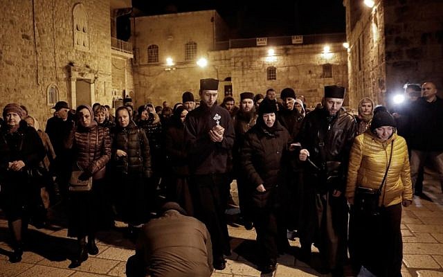 Christian worshippers prepare to enter the Church of the Holy Sepulchre in Jerusalem after it reopened on February 28, 2018, following a three-day closure to protest against Israeli tax measures and a proposed law. (AFP/THOMAS COEX)