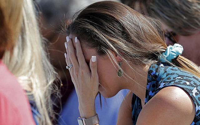 A woman cries as she prays during a vigil at the Parkland Baptist Church, for the victims of the Wednesday shooting at Marjory Stoneman Douglas High School, in Parkland, Fla., Thursday, Feb. 15, 2018. Nikolas Cruz, a former student, was charged with 17 counts of premeditated murder on Thursday. (AP Photo/Gerald Herbert)