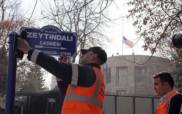An Ankara municipality worker fixes the new street sign, "Olive Branch Street" in Turkish, named after Turkey's military operation to drive out the Syrian Kurdish militia of an enclave in northwest Syria, in Ankara, Turkey, on February 19, 2018. (AP Photo/Burhan Ozbilici)