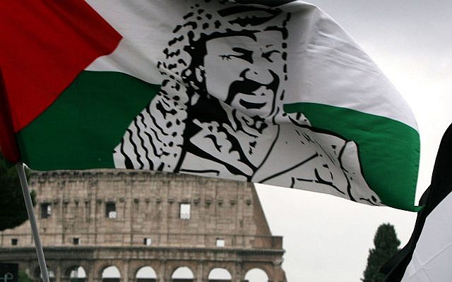 A demonstrator waves a Palestinian flag portraying Yasser Arafat during a demonstration in front of Rome's Colosseum Saturday, Oct. 30, 2004. (AP/Alessandra Tarantino)