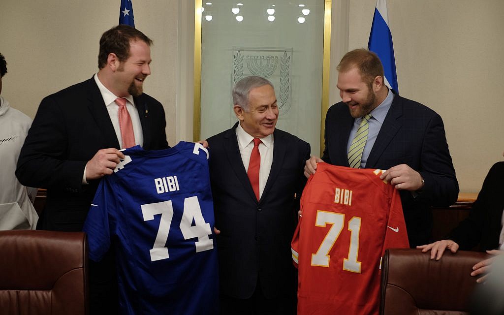 Jewish NFL football players and brothers Geoff (l) and Mitchell (r) Schwartz present Prime Minister Benjamin Netanyahu with football jerseys that have his nickname on them, in his Jerusalem office, on February 19, 2018. (Judah Ari Gross/Times of Israel)