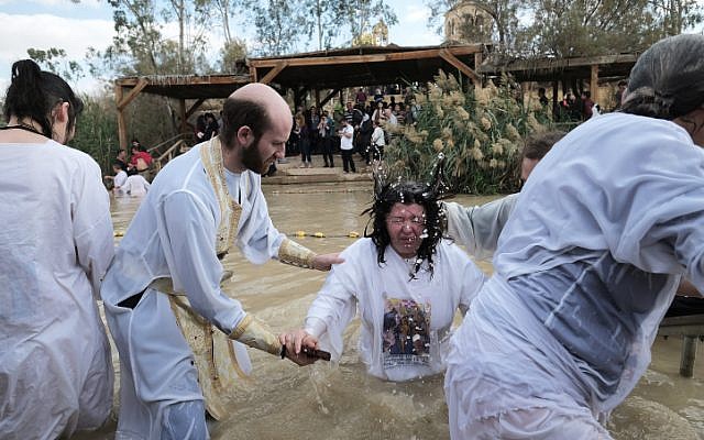 Orthodox Christian pilgrims take a dip in the Jordan river as part of a traditional Epiphany baptism ceremony at the site of Qasr el Yahud on January 18, 2018.(Yaniv Nadav/Flash90)