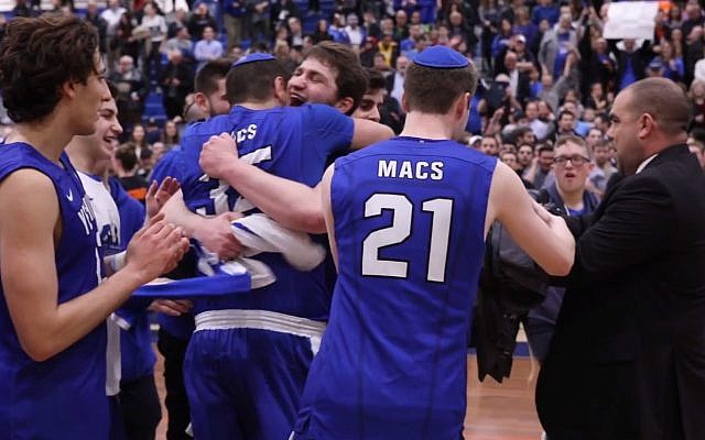 Basketball players in Yeshiva University Maccabees team celebrate their winning their first-ever Skyline Conference Championship on February 25, 2018. (Screen capture: YouTube)