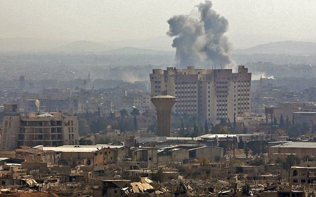 A picture taken from a government-controlled area on the outskirts of Harasta on the northeastern suburbs of Damascus on February 21, 2018, shows smoke rising from areas targeted by Syrian army shelling in the towns of Arbin and Harasta. (AFP PHOTO)