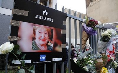A photograph of murdered Holocaust survivor Mireille Knoll is placed along with flowers on the fence surrounding her building in Paris on March 28, 2018. (Francois Guillot/AFP)