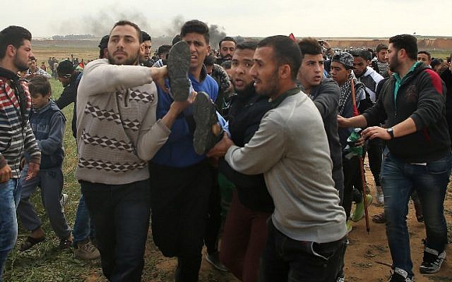 A picture taken on March 30, 2018 shows a Palestinian youth being carried on a stretcher after being injured during a demonstration near the border with Israel east of Jabalia in the Gaza strip commemorating Land Day. (AFP/ Mohammed ABED)