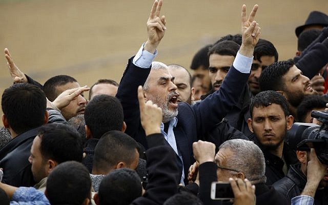 Islamist Hamas terror group leader Yihya Sinwar shouts slogans and flashes the victory gesture as he takes part in a protest near the border with Israel east of Jabaliya in the northern Gaza Strip on March 30, 2018. (AFP/ Mohammed ABED)