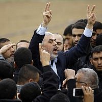 Islamist Hamas terror group leader Yahya Sinwar shouts slogans and flashes the victory gesture as he takes part in a protest near the border with Israel east of Jabaliya in the northern Gaza Strip on March 30, 2018. (AFP/ Mohammed ABED)