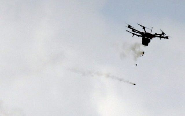 A picture taken on March 30, 2018 shows a Border Police drone dropping tear gas canisters during clashes with Palestinian protesters near the border with Israel, east of Gaza City. (AFP PHOTO / MAHMUD HAMS)