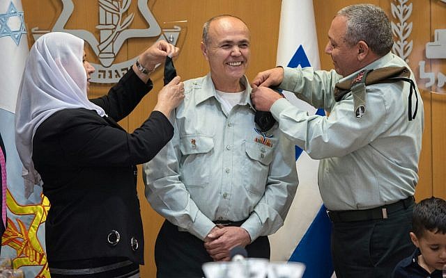 Kamil Abu Rokon, center, Israel's next liaison to the Palestinians, receives the rank of major general from IDF Chief of Staff Gadi Eisenkot, right, and Abu Rokon's wife in a ceremony at the army's Tel Aviv headquarters on March 29, 2018. (Israel Defense Forces)