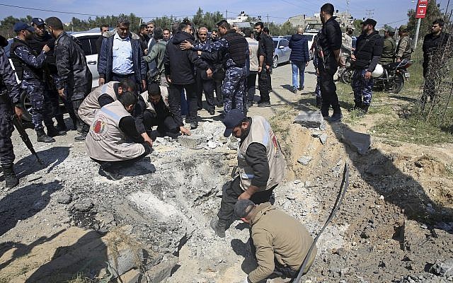 Hamas personnel inspect the site of an explosion that occurred as the convoy of Palestinian Authority Prime Minister Rami Hamdallah entered Gaza through the Erez crossing with Israel, on the main road in Beit Hanoun, Gaza Strip, on March 13, 2018. (AP Photo/Adel Hana)