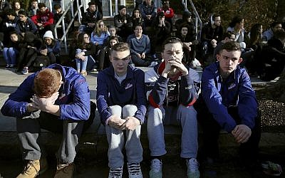 In this February 28, 2018, file photo, Somerville High School students sit on the sidewalk on Highland Avenue during a student walkout at the school in Somerville, Massachusetts. (Craig F. Walker/The Boston Globe via AP, File)