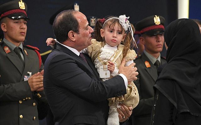 In this March 15, 2018 photo provided by Egypt's state news agency, MENA,Egyptian President Abdel-Fattah el-Sissi holds a child at an education seminar in Cairo, Egypt. (MENA via AP)