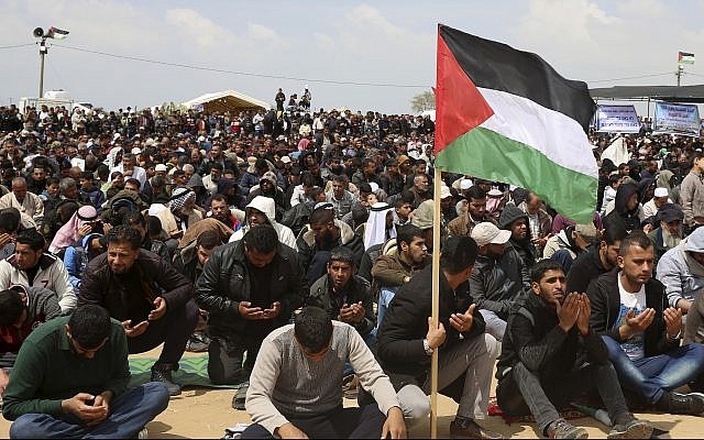 Manifestanti palestinesi pregano durante una manifestazione contro Israele lungo il confine della Striscia di Gaza ad est di Khan Younis, venerdì 30 marzo 2018. Credits to: AP/Adel Hana.