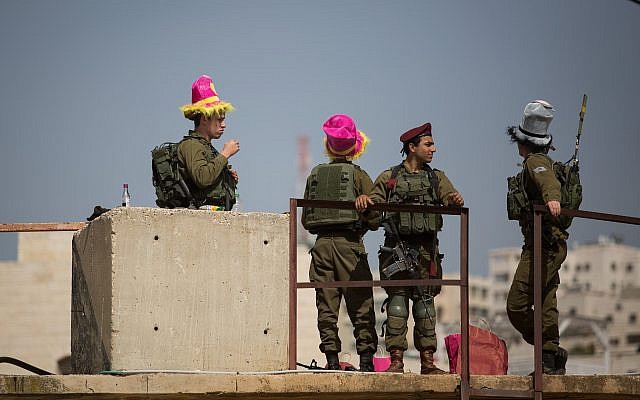 Israeli soldiers stand guard during the annual parade marking the Jewish holiday of Purim in the West Bank city of Hebron on March 1, 2018. (Hadas Parush/Flash90)