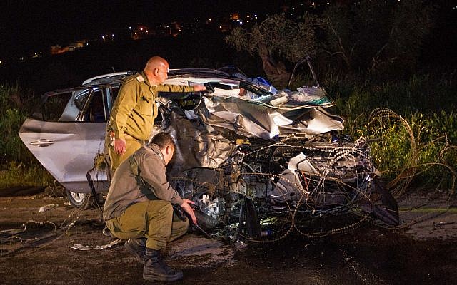 Israeli soldiers inspect a car at the scene where two Israeli soldiers were killed and another two were injured in a car-ramming terror attack near Mevo Dotan, in the West Bank, March 16, 2018. (Meir Vaknin/Flash90)