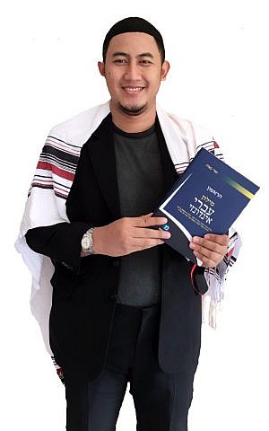 A Indonesian student of Hebrew holding Sapri Sale’s Hebrew-Indonesian dictionary (courtesy)