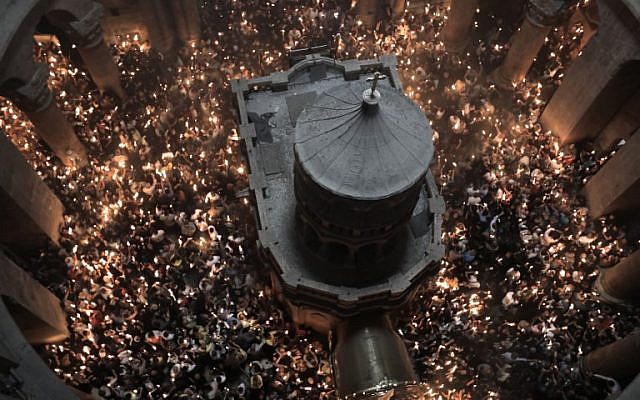 Christian Orthodox worshippers hold up candles during the ceremony of the "Holy Fire" as they gather in the Church of the Holy Sepulchre in Jerusalem's Old City, on April 7, 2018, during Orthodox Easter ceremonies.(AFP PHOTO / MENAHEM KAHANA)
