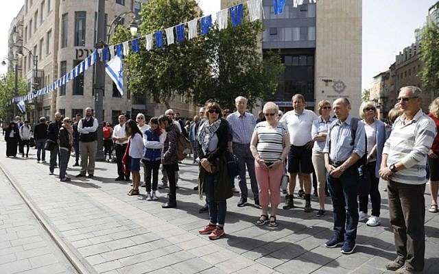 People stop and stand in silence on a Jerusalem's downtown street on April 12, 2018, as sirens wailed across Israel for two minutes marking the annual day of remembrance for the six million Jewish victims of the Nazi genocide. (AFP PHOTO / Menahem KAHANA)