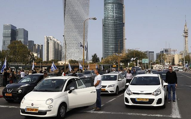 Drivers stop and stand in silence on a street in the Israeli city of Tel Aviv on April 12, 2017 as sirens wailed across Israel for two minutes marking the annual day of remembrance for the six million Jewish victims of the Nazi genocide. (AFP PHOTO / JACK GUEZ)