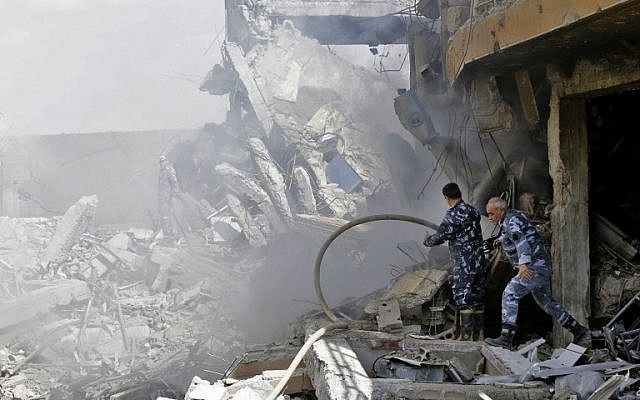 Syrian soldiers inspect the wreckage of a building described as part of the Scientific Studies and Research Center (SSRC) compound in the Barzeh district, north of Damascus, during a press tour organised by the Syrian information ministry, on April 14, 2018. (AFP / LOUAI BESHARA)