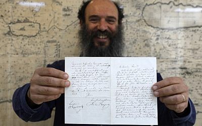 Meron Eren, co-founder and owner of the Kedem auction house, holds a letter by German anti-Semitic composer Richard Wagner in Jerusalem on April 16, 2018. (Menahem Kahana/AFP)
