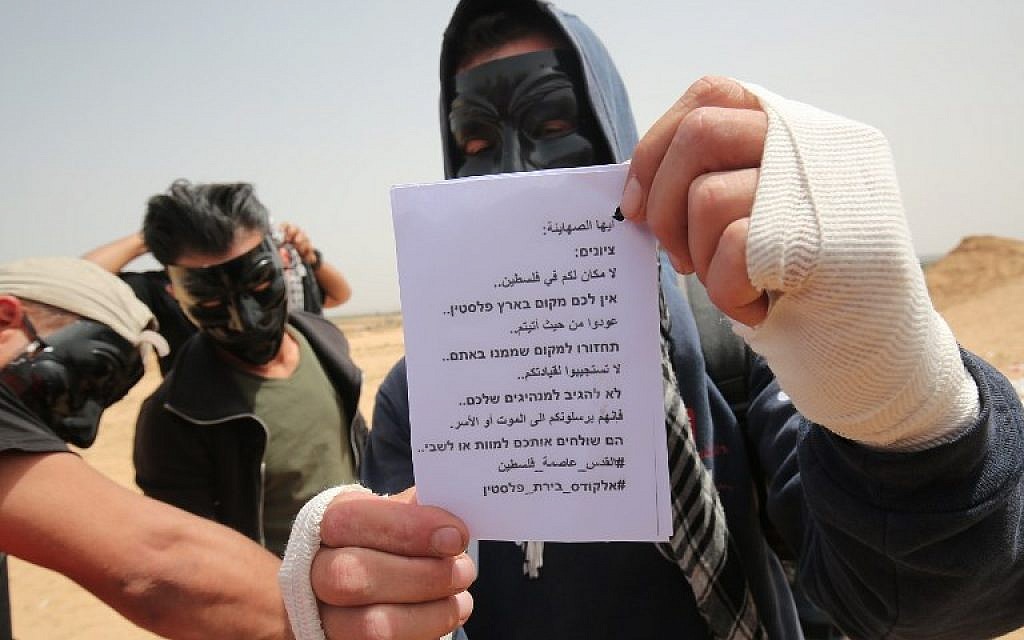 Palestinians display leaflets that will be attached to kites carrying firebombs before being flown over the border fence with Israel, Rafah, southern Gaza Strip, April 20, 2018. The message on the leaflet reads in Hebrew and in Arabic, 'Zionists: There is no place for you in Palestine. Go back to where you came from. Do not obey your leaders. They send you to death or captivity. #Jerusalem capital of Palestine" (AFP Photo/Said Khatib)