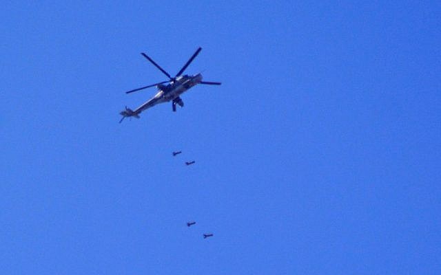 A MI24 Syrian army helicopter drops barrel bombs over southern Damascus in the area of the Palestinian refugee camp of Yarmouk on April 27, 2018. (AFP Photo/Rami Al Sayed)