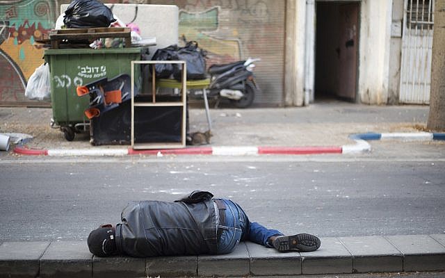 In this Tuesday, April 3, 2018 photo, an African migrant sleeps in a street in southern Tel Aviv. (AP Photo/Ariel Schalit)