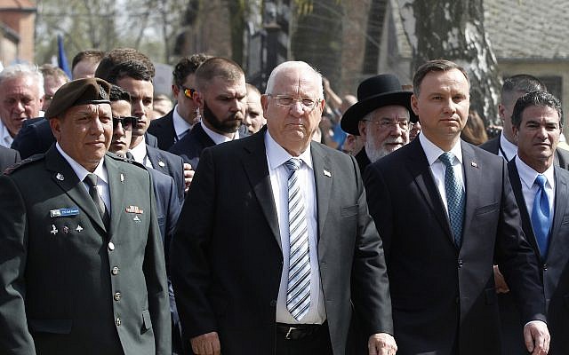 Poland's President Andrzej Duda, left, and Israel's President Reuven Rivlin, center, walk in the March of the Living, a yearly Holocaust remembrance march between the former death camps of Auschwitz and Birkenau, in Oswiecim, Poland, on Thursday, April 12, 2018. (AP Photo/Czarek Sokolowski)