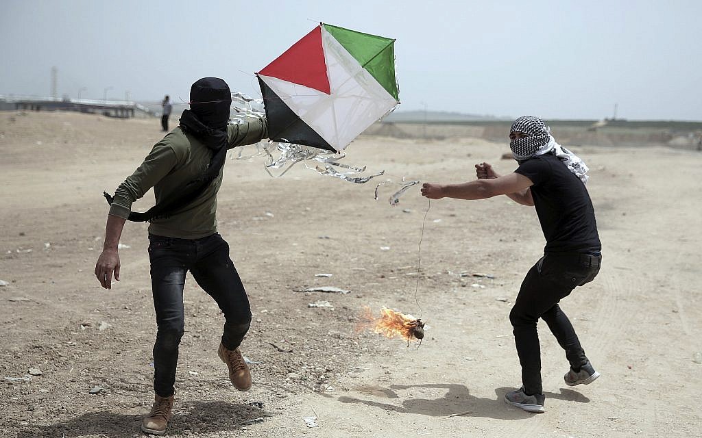 Illustrative: Palestinian protesters fly a kite with a burning rag dangling from its tail, during a protest at the Gaza Strip's border with Israel, April 20, 2018. (AP Photo/Khalil Hamra)