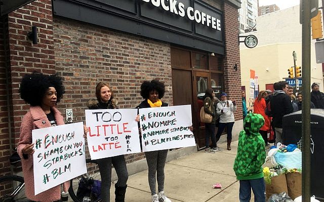 Protesters gather outside a Starbucks in Philadelphia, Sunday, April 15, 2018, where two black men were arrested Thursday after Starbucks employees called police to say the men were trespassing. (AP Photo/Ron Todt)