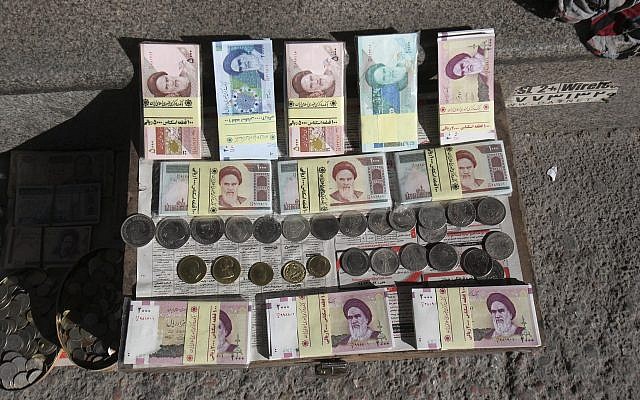 Illustrative photo of Iranian banknotes and foreign coins displayed by a vendor on a side walk of the Ferdowsi Street in Tehran, Iran, January 23, 2013. (Vahid Salemi/AP)
