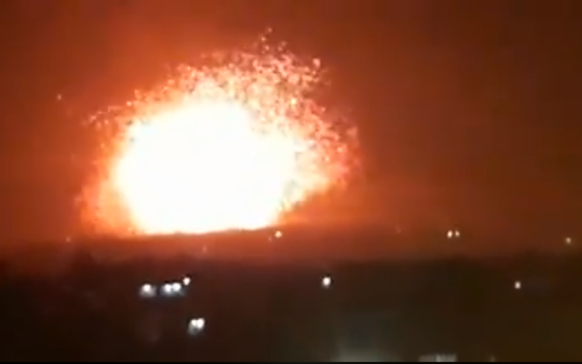 An explosion is seen coming from an army base, allegedly used by Iran-backed militias, outside the northern Syria city of Hama on April 29, 2018. (Screen capture; Facebook)