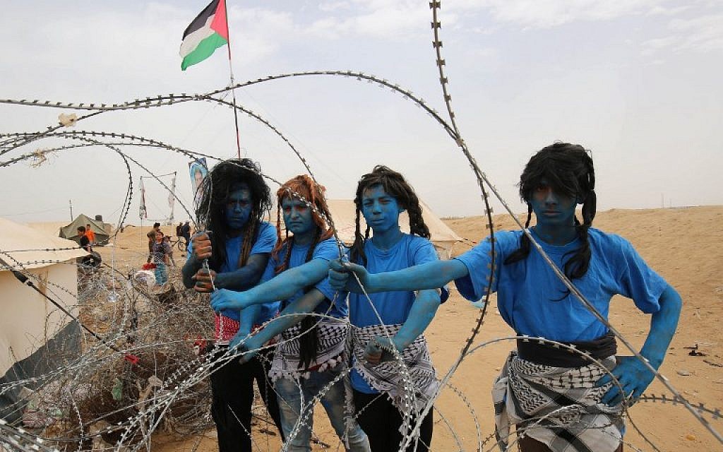 Palestinians with their faces painted like characters from the movie "Avatar" pose for a picture ahead of the weekly "March of Return" clashes on the border between the Gaza Strip in Israel, east of Khan Younis in southern Gaza, on May 4, 2018. (AFP Photo/Said Khatib)
