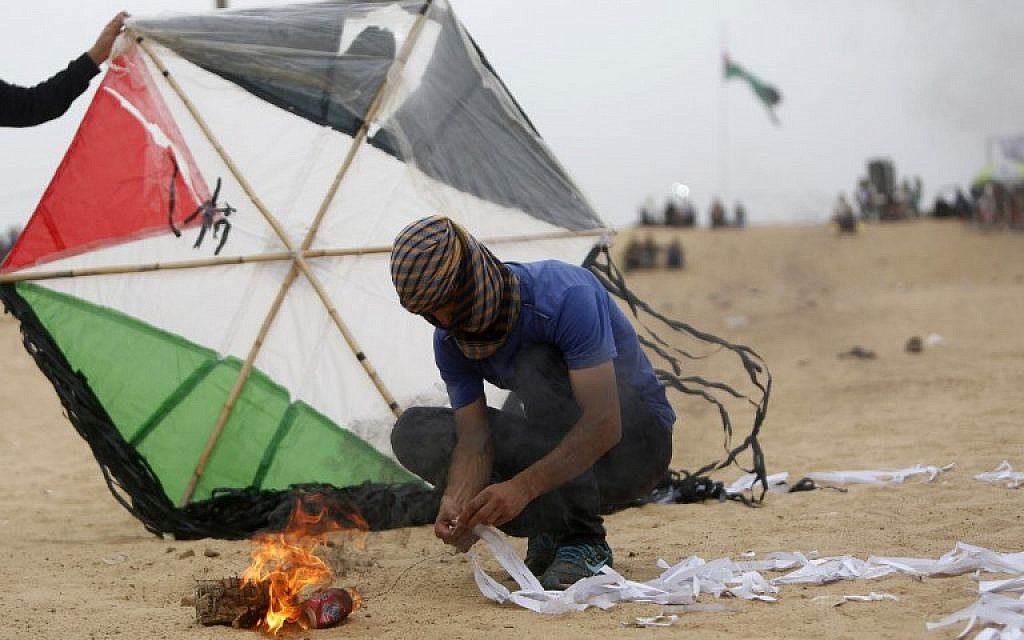 Illustrative: Palestinians prepare an incendiary device attached to a kite before trying to fly it over the border fence with Israel, on the eastern outskirts of Jabaliya, on May 4, 2018. (AFP Photo/Mohammed Abed)