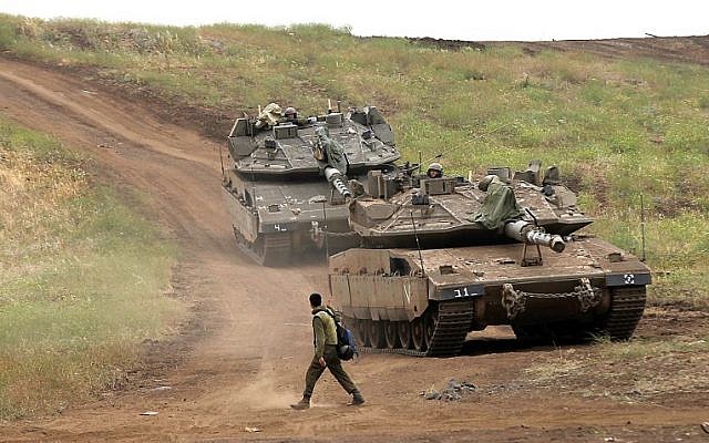 An Israeli soldier next to Merkava Mark IV tanks in the Golan Heights during a military drill on May 7, 2018. (AFP PHOTO / JALAA MAREY)