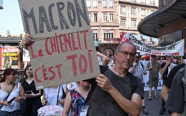 A man holds a placard reading "Macron the havoc it's you" during a "maree populaire" (working-class tide) demonstration called by political organisations, associations and unions to protest against the French President and government's policy, in Strasbourg on May 26, 2018. (AFP PHOTO / PATRICK HERTZOG)