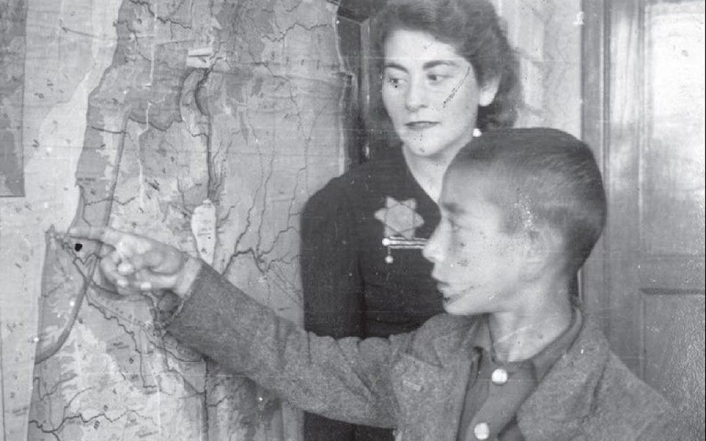 A teacher and a student near a map of the Land of Israel in the Łódź ghetto, Poland. (Yad Vashem Archives Collection)