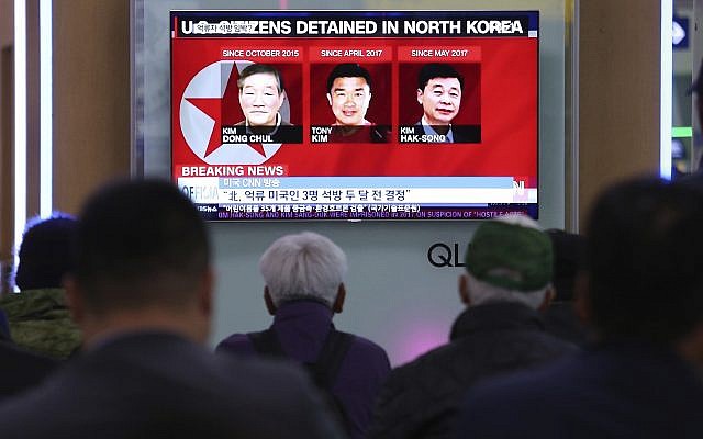 In this May 3, 2018 photo, people watch a TV news report screen showing portraits of three Americans, Kim Dong Chul, left, Tony Kim and Kim Hak Song, right, detained in the North Korea, at the Seoul Railway Station in Seoul, South Korea. (AP Photo/Ahn Young-joon)