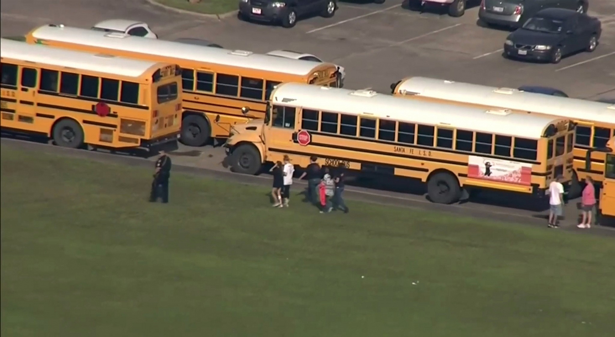In this image taken from video a police officer walks near school buses as law enforcement officers respond to a high school near Houston after an active shooter was reported on campus, Friday, May 18, 2018, in Santa Fe, Texas. (KTRK-TV ABC13 via AP)