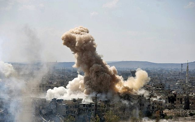 In this file photo released on Sunday, April 22, 2018 by the Syrian official news agency SANA, smoke rises after Syrian government airstrikes and shelling hit in Hajar al-Aswad neighborhood held by Islamic State militants, southern Damascus, Syria.  (SANA via AP)