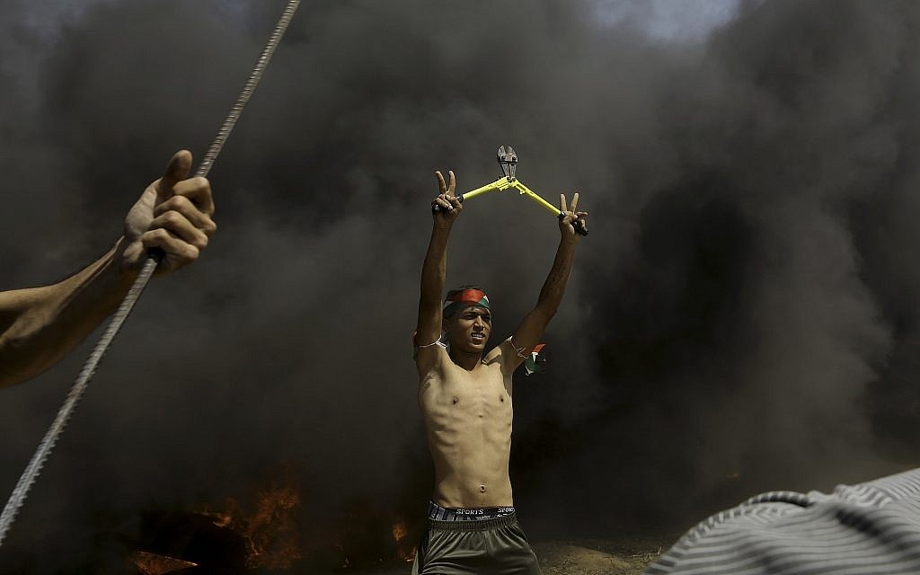 A Palestinian protester holds wire cutters amid black smoke from burning tires near the fence during a protest at the Gaza Strip's border with Israel, May 11, 2018.  (AP Photo/Adel Hana)