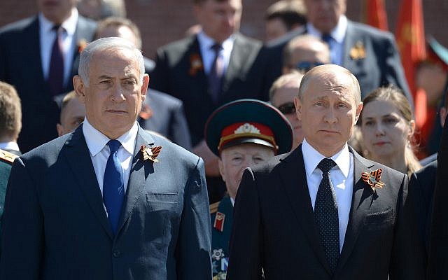 Prime Minister Benjamin Netanyahu (left) and Russian President Vladimir Putin during a wreath-laying ceremony at the Tomb of the Unknown Soldier in Moscow, on May 9, 2018. Both men are wearing the orange and black St. George ribbon (Amos Ben Gershom/GPO)