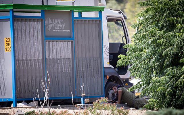 Illustrative: An Israeli soldier takes cover as rocket sirens blare in southern Israel on May 29, 2018. (Yonatan Sindel/Flash90)