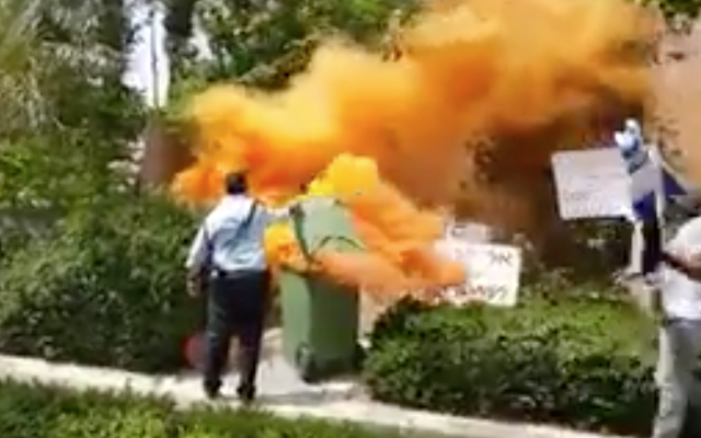 Orange smoke rises from smoke bombs near Prime Minister Benjamin Netanyahu's  home in Caesarea, May 25, 2018 (Kan TV news screenshot)