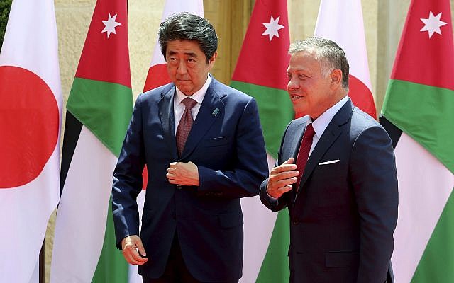 Japanese Prime Minister Shinzo Abe, left, is welcomed by King Abdullah II of Jordan at the Husseiniya palace in Amman, Jordan, May 1, 2018. (AP Photo/Raad Adayleh)