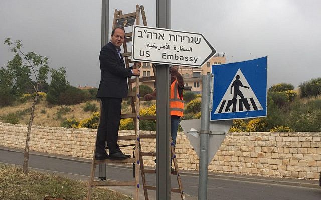 Jerusalem Mayor Nir Barkat hangs the first sign pointing to the new US Embassy in Jerusalem, May 7, 2018 (Jerusalem Municipality)