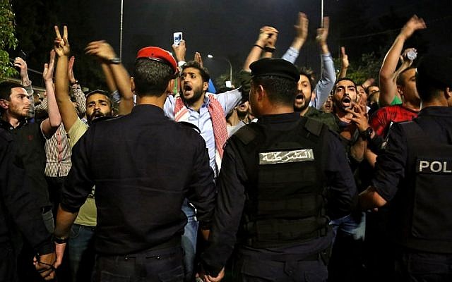 Protesters confront anti-riot policemen as they protest against against a proposed income tax draft law in front of the Prime Minister's office in Amman, late on June 1, 2018.(AFP PHOTO / STRINGER)
